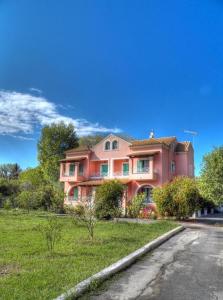 a large pink house on the side of a street at Villa Marina in Ipsos