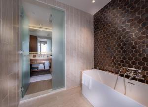 a bathroom with a tub and a sink at Hard Rock Hotel Desaru Coast in Desaru