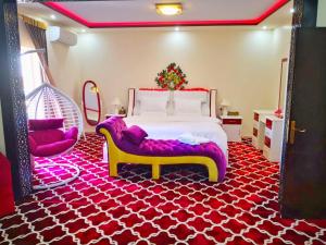 a bedroom with a large bed and a red and white carpet at Almudawah Hotel in Ţurayf