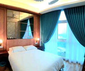 a bedroom with a bed and a large window at LUXURIOUS EXQUISITE SEAVIEW PRIVATE MARINA CONDOMINIUM in Nusajaya