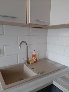un bancone della cucina con lavandino e detersivo arancione di Apartment in Serbska Lviv a Lviv