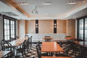 a dining room with wooden tables and chairs at AVA Hotel in Phitsanulok