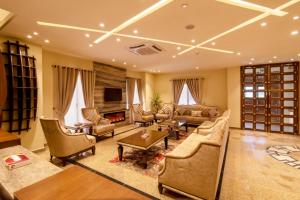 a large living room with couches and a fireplace at Hotel One Garden Town, Lahore in Lahore