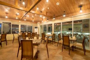 a restaurant with wooden ceilings and tables and chairs at Hotel One Garden Town, Lahore in Lahore