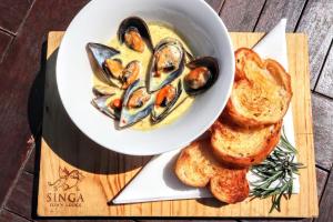 a bowl of oysters and bread on a cutting board at Singa Lodge - Lion Roars Hotels & Lodges in Port Elizabeth