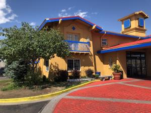 a yellow house with a red carpet in front of it at Americas Best Value Inn Denver in Denver