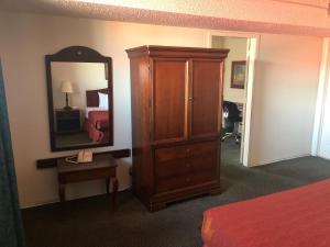 Un dormitorio con un gran armario de madera y un espejo. en Americas Best Value Inn Denver, en Denver