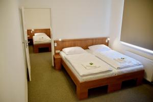 a small bedroom with two beds and a mirror at Penzion Panský dvůr Telč in Telč