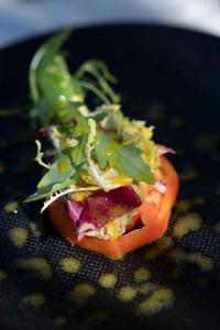 a sandwich with lettuce and tomato on a black plate at Le Spinaker in Le Grau-du-Roi