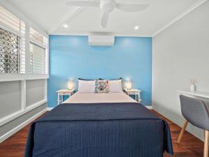 a bedroom with a blue wall and a bed at Almare Tourist Motel in Ballina