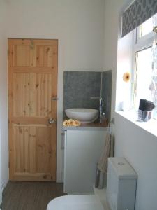 ein Bad mit einem WC, einem Waschbecken und einer Tür in der Unterkunft Carvetii - Gemini House - 4 bed House sleeps up to 8 people in Tillicoultry