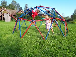 a little girl playing in a play structure at Wilcza Jama - domki, sauna in Lutowiska
