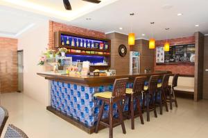 a restaurant with a bar with wooden stools at Good Nice Hotel in Patong Beach