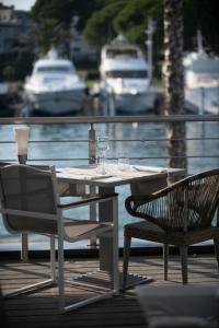 een tafel en stoelen op een terras met uitzicht op het water bij Le Spinaker in Le Grau-du-Roi