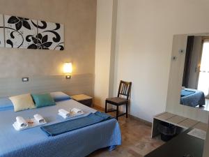 a bedroom with a bed and a chair and a mirror at B&B Monté in Montesilvano +37 photos