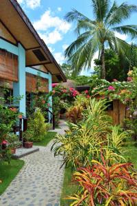 un giardino con piante e un vialetto accanto a un edificio di Angel Nido Resort a El Nido