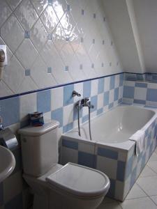 ein Badezimmer mit einem WC und einer Badewanne in der Unterkunft Hotel Paříž in Jičín