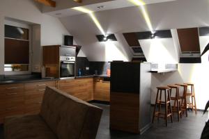 a kitchen with wooden cabinets and a bar with stools at Aparts Oberhausen in Oberhausen