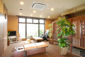 a living room with a couch and a plant at Hotel Route-Inn Shiojiri in Shiojiri