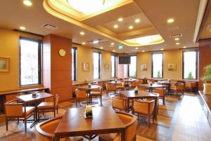 a restaurant with tables and chairs in a room at Hotel Route-Inn Shiojiri in Shiojiri