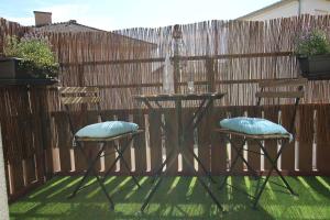 a patio table and two chairs with pillows on it at Colmar City Center - SCHNAPSALA Terrasse and Free Parking - BookingAlsace in Colmar