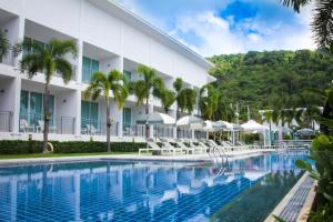 a swimming pool in front of a hotel at The Palmery Resort - SHA Extra Plus in Kata Beach