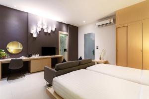 um quarto com uma cama e uma secretária em The Palmery Resort em Kata Beach