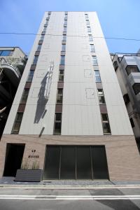 HOTEL AMANEK Ginza East في طوكيو: مبنى طويل عليه تمثال رجل