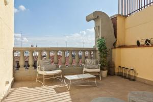 - un balcon avec deux chaises et un banc dans un bâtiment dans l'établissement Canaan Boutique Apartments Madrid, à Madrid