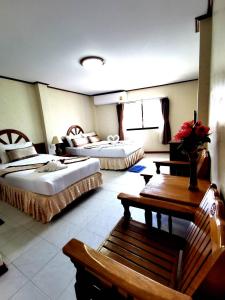 a hotel room with two beds and a bench at Natacha Hotel in Phi Phi Islands