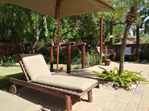 a reclining chair and an umbrella on a patio at Journey's Inn Africa Airport Lodge in Kempton Park