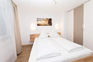 メッツィンゲンにあるOutlet-Apartment Metzingenの白いベッドルーム(白いシーツと枕付きのベッド1台付)