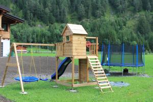 un parque infantil de madera con escalera y tobogán en Villa Alpin, en Holzgau