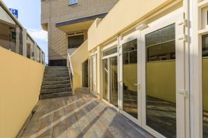 un couloir vide d'un immeuble avec des portes vitrées dans l'établissement Lage Wurft Beach Apartments, à Noordwijk