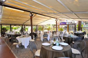 um salão de banquetes com mesas e cadeiras com toalha de mesa branca em Hotel Frate Sole em Assisi