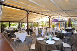 un salón de banquetes con mesas y sillas y mantel blanco en Hotel Frate Sole, en Asís