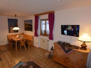 a living room with a table and a television on the wall at Ferienwohnungen Romeo-Julio-Mittenwald in Mittenwald +24 photos