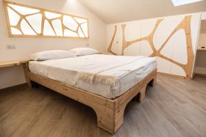 ein großes Bett in einem Zimmer mit Fenster in der Unterkunft A Casa Di in Alvito