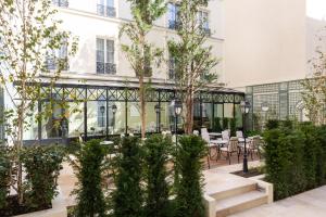 un patio con mesas y sillas en un edificio en Lord Byron, en París