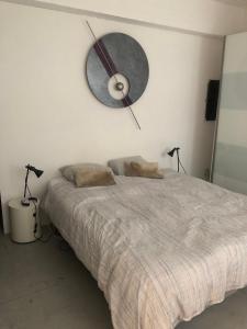 a bedroom with a bed with a clock on the wall at B&B Loft Jamar Gare Du Midi in Brussels