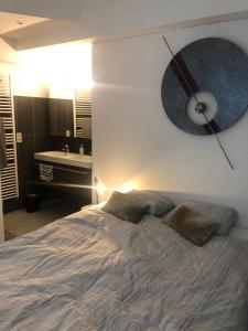 a bedroom with a bed with a clock on the wall at B&B Loft Jamar Gare Du Midi in Brussels