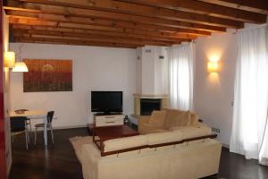 Una sala de estar con un sofá y un televisor. en Accogliente appartamento moderno, vicino a Venezia, en Mestre 6 fotos más
