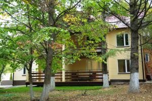 a yellow house with trees in front of it at Valesko Hotel in Grigorchikovo