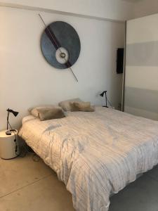 1 dormitorio con 1 cama con reloj en la pared en B&B Loft Jamar Gare Du Midi, en Bruselas