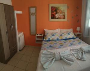 - une chambre avec un lit doté d'une cravate dans l'établissement Apartamentos beira mar, à Porto de Galinhas