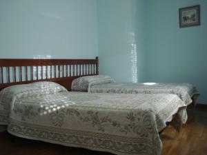2 camas en una habitación con paredes azules en Hostal ** EC León en León