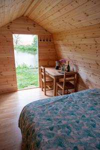 - une chambre avec un lit, une table et une fenêtre dans l'établissement The Moat Lake Glamping Pod, à Clare
