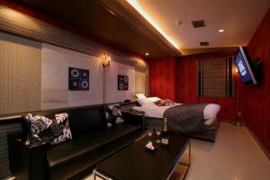 a hotel room with a bed and a couch at HOTEL BANJAR in Tokorozawa