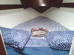 Una cama con almohadas de lunares con camisa. en Inolvidable experiencia en un velero de 11 metros! en Zumaia