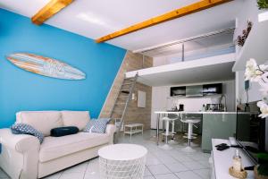 a living room with a couch and a surfboard on the wall at 2 pièces avec grande terrasse - Centre de Toulon in Toulon